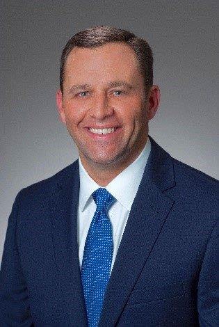 A person in a suit smiling

Description automatically generated with medium confidence